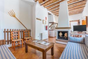 a living room with a table and a fireplace at El Cobertizo in La Zubia