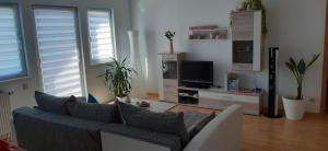 a living room with a couch and a tv at Ferienwohnung Am Bahnhof in Hochkirch
