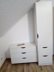 a bedroom with a white dresser and a closet at Ferienwohnung Am Bahnhof in Hochkirch