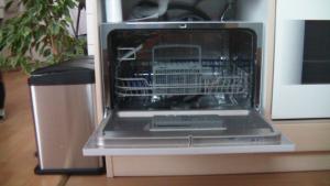 a dishwasher with its door open with a bird cage inside at Ferienwohnung Am Bahnhof in Hochkirch