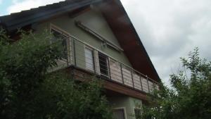 a balcony on the side of a building with trees at Ferienwohnung Am Bahnhof in Hochkirch