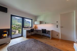 a home office with a desk and a large window at Levita Living Anima in Tirolo