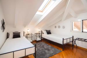 a attic bedroom with two beds and a window at Appartamento Villa Antonia in Marina di Andora +36 photos