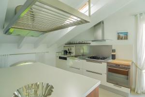 a kitchen with white cabinets and a large window at Appartamento Villa Antonia in Marina di Andora
