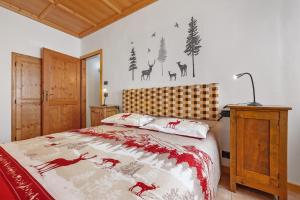 a bedroom with a bed with a red and white blanket at Appartamento Ca' Mocc in Porte di Rendena