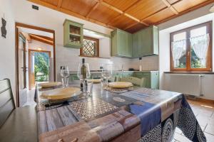 a kitchen with a wooden table with glasses on it at Appartamento Ca' Mocc in Porte di Rendena