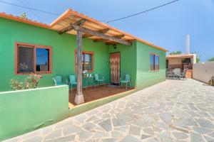 a green house with a table and chairs on a patio at vv - La Casa Verde in Las Casas