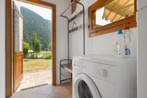 a washing machine in a room with a window at Appartamento Ca' Mocc in Porte di Rendena