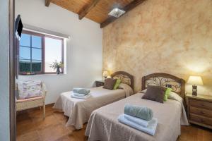 a bedroom with two beds and a window at vv - La Casa Verde in Las Casas