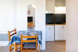 a kitchen and dining room with a table and chairs at Les Mimosas - Appartement 06 in Cazaubon
