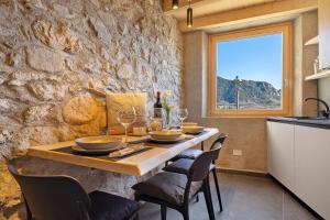 a table in a kitchen with a stone wall at Chalet Al Volt in Tremosine Sul Garda