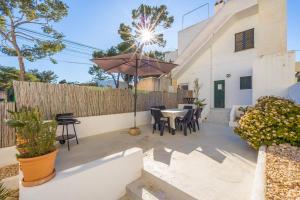 a patio with a table and an umbrella at Villa Lucia in Portocolom