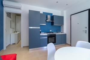 a kitchen with blue cabinets and white appliances at Verdemare a due passi dal mare in Villaggio Azzurro