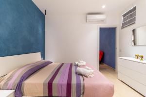 a bedroom with a bed and a blue wall at Verdemare a due passi dal mare in Villaggio Azzurro