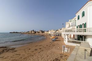 a view of a beach with a building and the ocean at Verdemare a due passi dal mare in Villaggio Azzurro