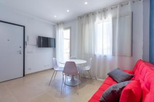 a living room with a red couch and a table at Verdemare a due passi dal mare in Villaggio Azzurro