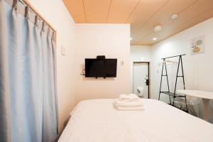 a bedroom with a bed and a tv on the wall at GLOU Akasaka Inn in Tokyo