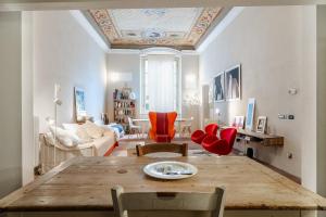 a living room with a wooden table and red chairs at L'affresco in Via Guinigi in Lucca