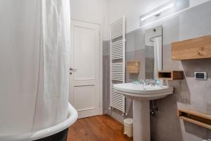 a white bathroom with a sink and a shower at L'affresco in Via Guinigi in Lucca