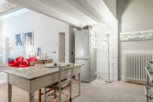 a kitchen with a table and red chairs in a room at L'affresco in Via Guinigi in Lucca +17 photos