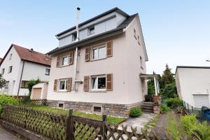 a white house with wooden windows and a fence at Fewo Sartorius in Bensheim