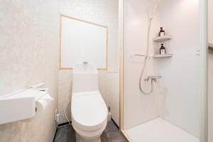 a white bathroom with a toilet and a shower at GLOU Akasaka Inn in Tokyo