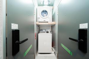 a room with a microwave and a washing machine at GLOU Akasaka Inn in Tokyo