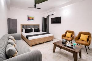 a bedroom with a bed and a couch and a table at Hotel Comfort Inn, Nangloi, Walking from Metro in New Delhi +2 photos