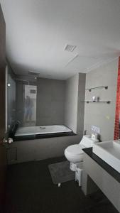 a bathroom with a toilet and a tub and a sink at joyful theKrisA205 in Ban Lum Fuang +11 photos