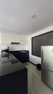 a kitchen with a black counter and a refrigerator at joyful theKrisA205 in Ban Lum Fuang