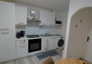 a kitchen with white cabinets and a stove top oven at Casa Elena in Ventimiglia