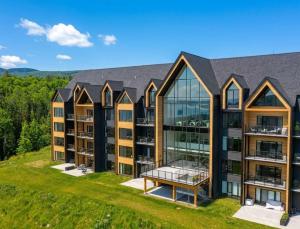 an aerial view of an apartment building with glass windows at 205 - Modern Suite - Pool and River View in Baie-Saint-Paul