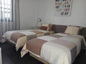 two beds sitting next to each other in a room at Departamento Barcaro 2 in Puerto del Carmen +23 photos