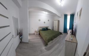 a bedroom with a green bed in a white room at Apart Alex in Constanţa