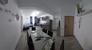a living room with a dining table and a kitchen at Apart Alex in Constanţa