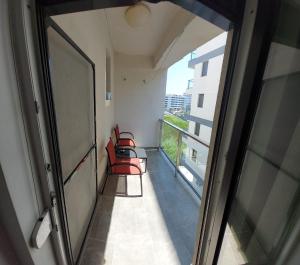 an empty hallway with red chairs and a window at Apart Alex in Constanţa