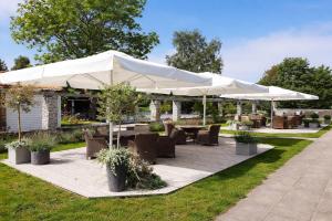 a patio with tables and chairs under a white umbrella at SleepCleanGo L3 in Gnisvärd +8 photos