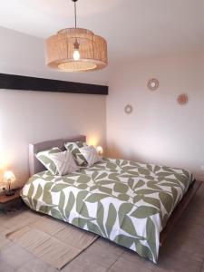 a bedroom with a bed with a green and white comforter at Le Cocon Des Roches in Cessieu