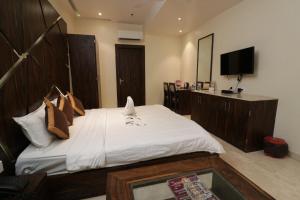 a bedroom with a large bed and a television at Eennra Guest House in Mālda +49 photos