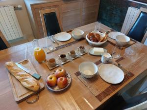 a table with plates of food and fruit on it at Le Cocon Des Roches in Cessieu