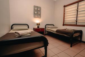 a room with two beds and a lamp in it at Kimberley Travellers Lodge in Broome