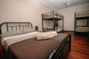a bedroom with a bed with two bunk beds at Kimberley Travellers Lodge in Broome