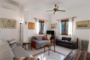 a living room with a couch and a ceiling fan at Arto's Villa With Private Pool- BY APOKORONAS VILLAS in Plaka