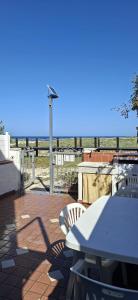 a table and chairs on a patio with the ocean in the background at Casa sul mare da Giovanna in La Caletta