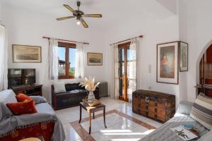 a living room with a couch and a ceiling fan at Arto's Villa With Private Pool- BY APOKORONAS VILLAS in Plaka