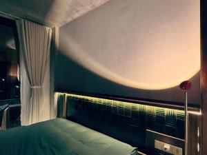 a bedroom with a green bed with a window at Chum Home - 02 in Danang +5 photos