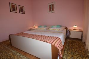 a bedroom with a bed with two lamps on two tables at Villa DELFINA in Podgora