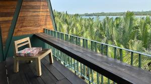 a chair on a balcony with a view of the water at Chum Home - 02 in Danang