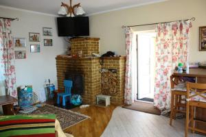 a living room with a brick fireplace and a television at БУДИНОК сімейних ПРИГОД in Vodniki