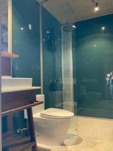 a bathroom with a toilet and a glass shower at Chum Home - 02 in Danang